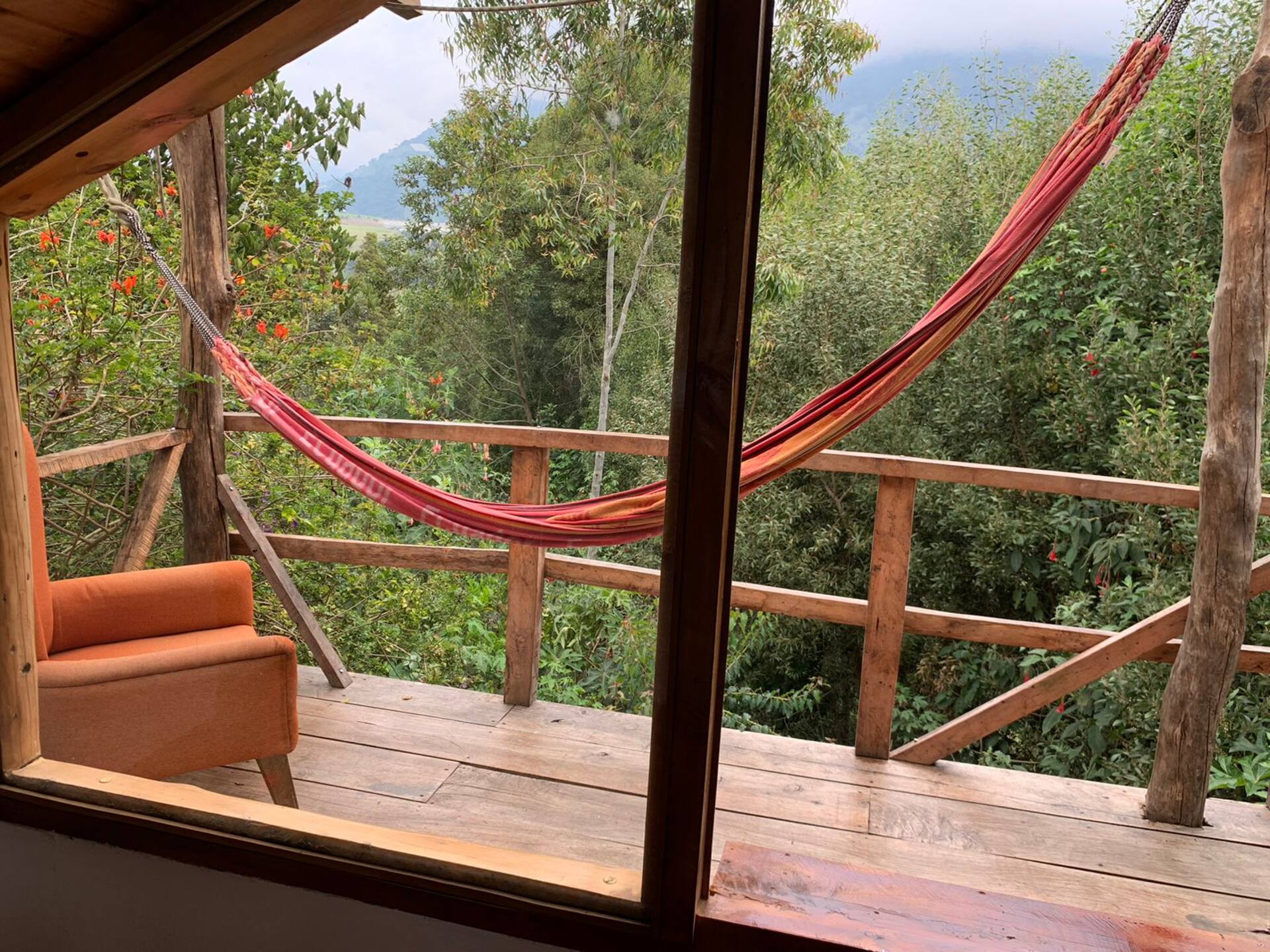Terraza de madera con hamaca y vista a las montañas de Baños